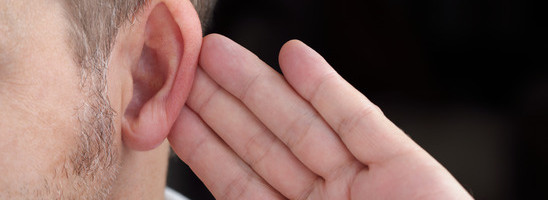 Man with hand on ear listening for quiet sound or paying attention