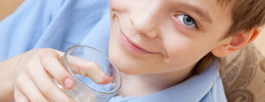Child drinking water. Boy drinking water from a glass